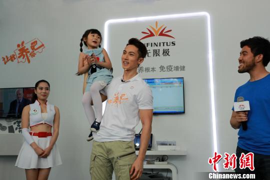 吴尊展现臂力，轻易地挂起一个重30多斤的小萌娃 程景伟 摄