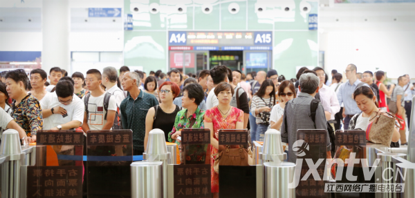 受台风影响，许多旅客更改行程，候车室内聚集了许多旅客，等候车站工作人员引导进站。