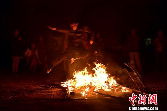 壮家汉子从燃烧的火堆上跳过去。　连清 摄