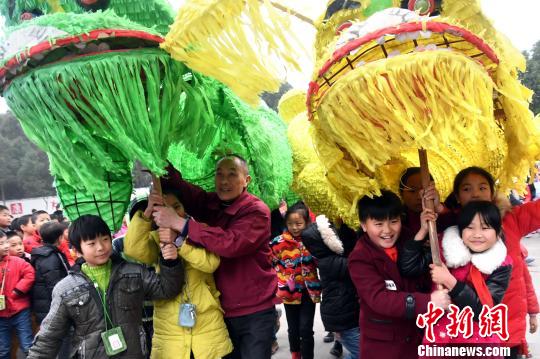 当地农民民俗表演队带着学生们一起表演双狮舞。　周亮摄