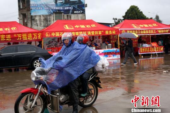 图为返乡民工骑摩托车驶进贺州春运服务站。　赵琳露摄