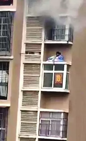 15楼起火妈妈抱孩子翻窗爬楼逃生 消防员:做对了